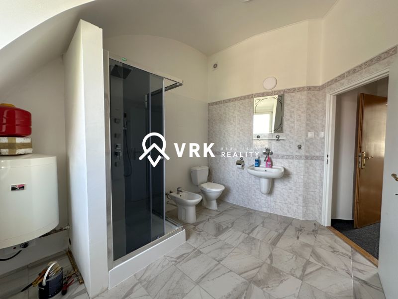 Bathroom with tiles, shower, sink, and toilet in the offices.