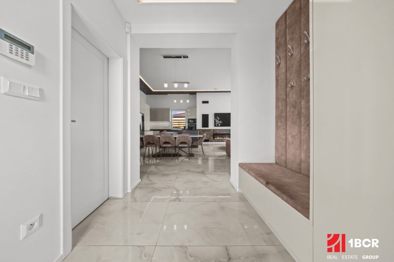 Interior of a family house with an open kitchen, dining area, and comfortable seating in the hallway.