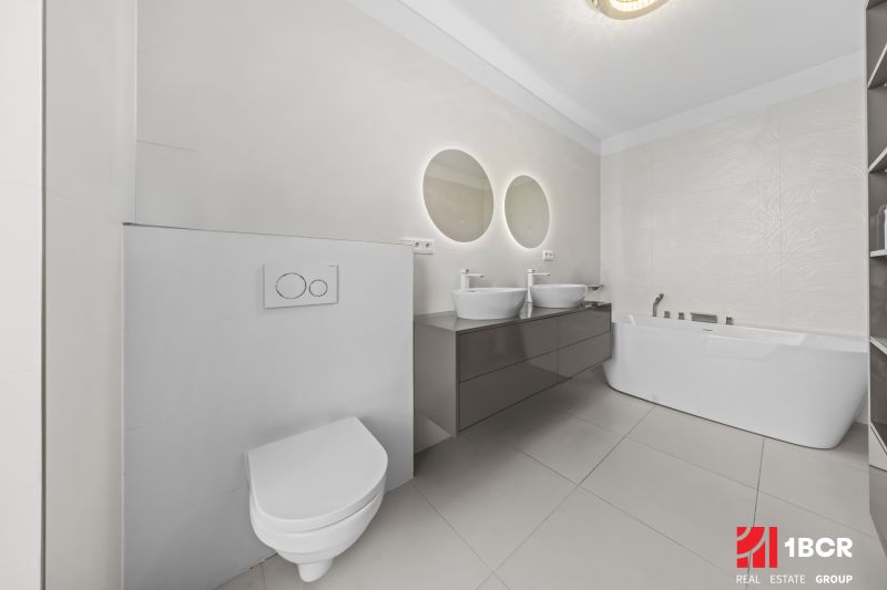 A bathroom with two sinks and a freestanding bathtub in a family house.