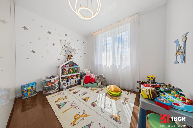 Children's room with toys, a colorful mat, and wall decorations in a family house.