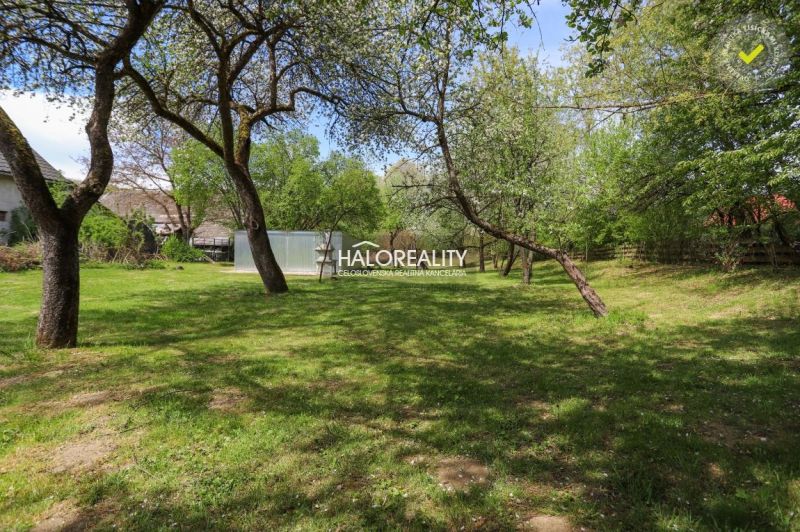 Gardens in Považská Bystrica with fruit trees and a shelter on the edge of the property.