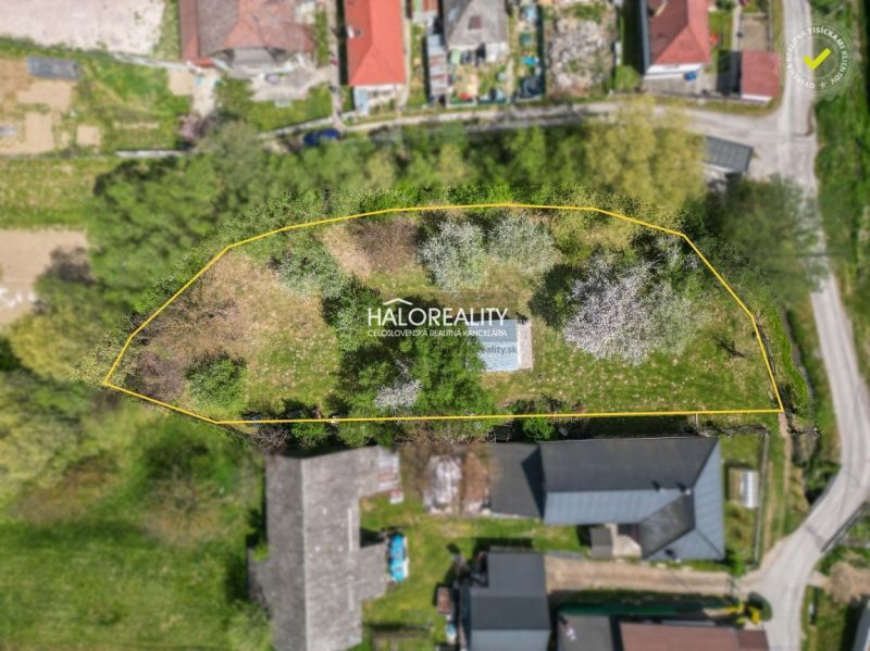 Aerial view of gardens in Považská Bystrica, surrounded by residential buildings and greenery.