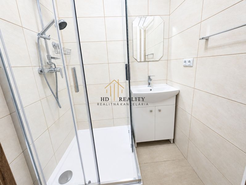 Bathroom with a shower and a sink in a 2-room apartment.