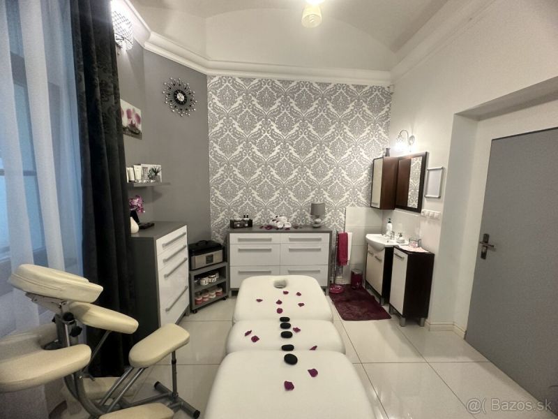 Massage room with a decorated wall, table, and lounger for relaxation treatments.