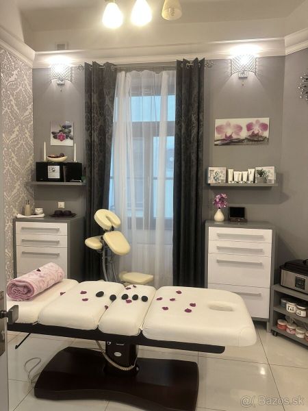 Massage room in commercial premises with a white couch, decorations, and flowers.