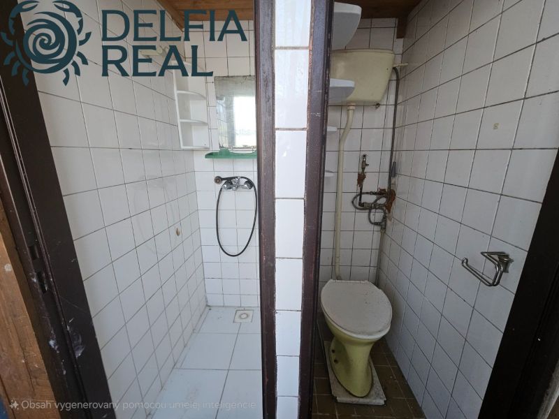 A bathroom in a cabin with a shower and toilet, tiles, white tiles.
