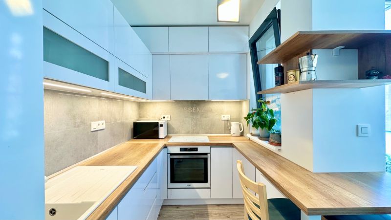A bright kitchen with built-in appliances and wooden decor in a 2-room apartment.