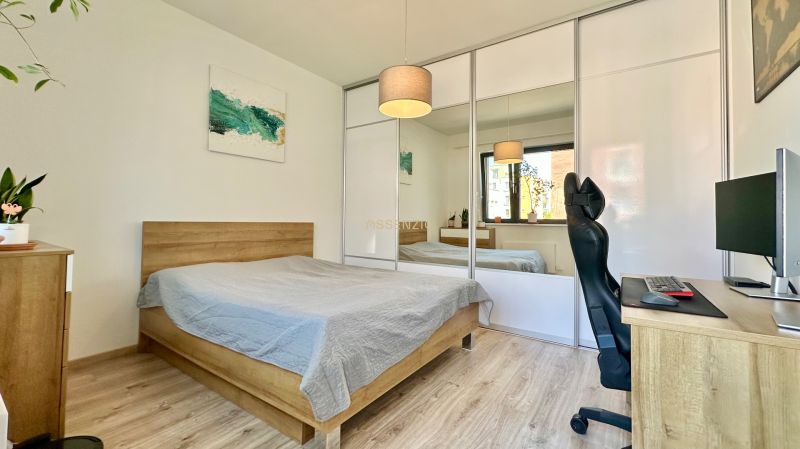 Bedroom in a 2-room apartment with a bed, wardrobe, and desk.