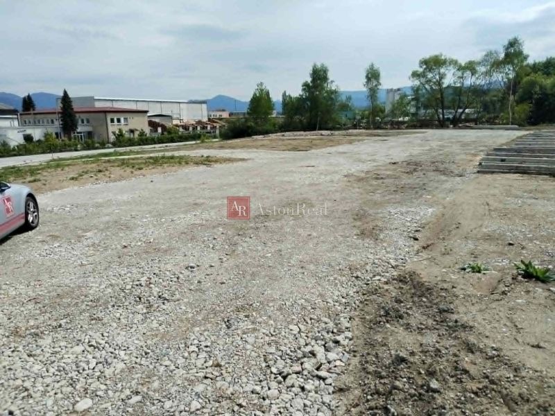 Land - commercial in Martin with a rocky surface and proximity to an industrial building.