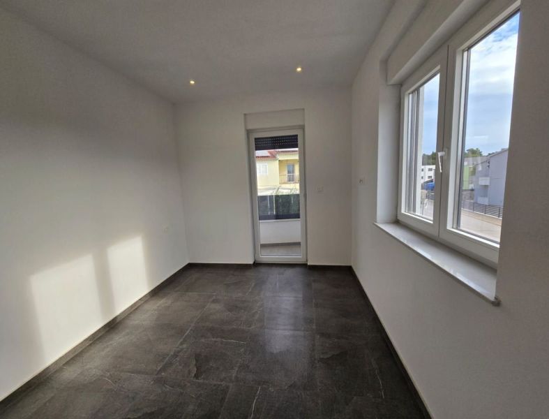A bright room with windows and a balcony in a family house, floor with a dark decor.