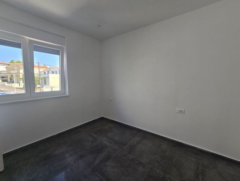 A room in a family house with a ceramic floor and a view of the street.