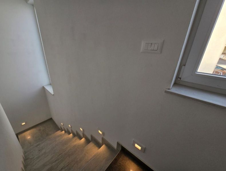 A staircase with integrated lighting and a window in a family house.