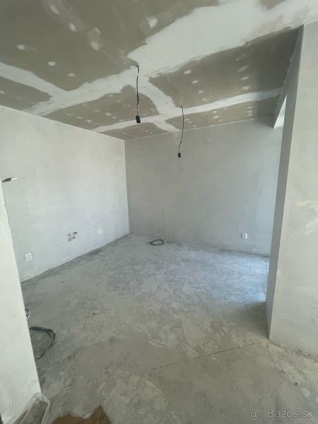 Interior in a 3-room apartment with a concrete floor and unplastered walls.