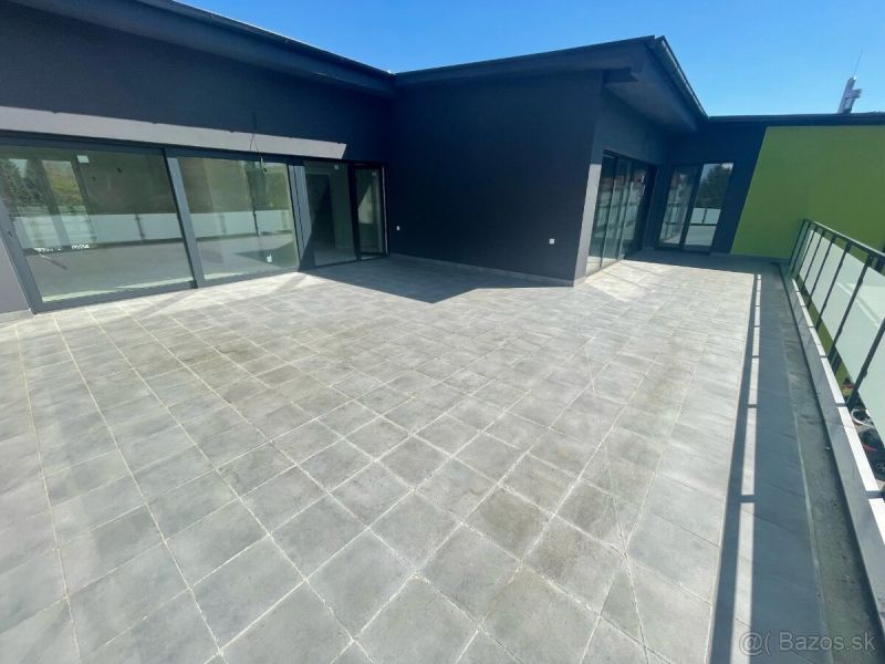 Spacious terrace at a 3-room apartment in the town of Svit with large glass doors.