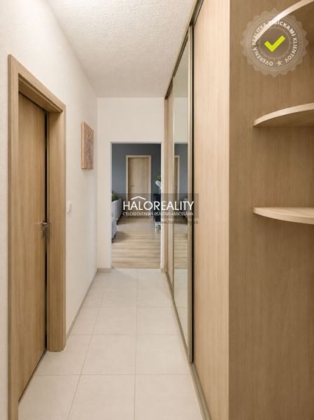 A hallway with a mirrored wardrobe in a 2-room apartment with a wooden decor.