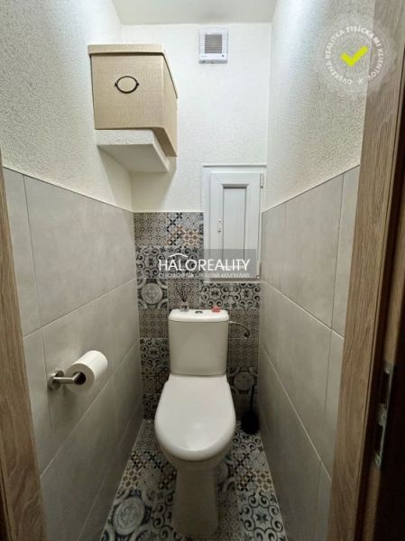 Bathroom with toilet in a 2-room apartment, light walls, patterned tiles.