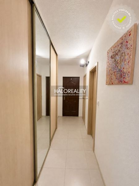 A hallway in a 2-room apartment with tiles, a built-in wardrobe, and a picture on the wall.