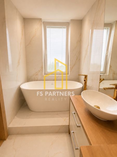 Bathroom with a bathtub and a sink in a 3-room apartment, light marble decor.