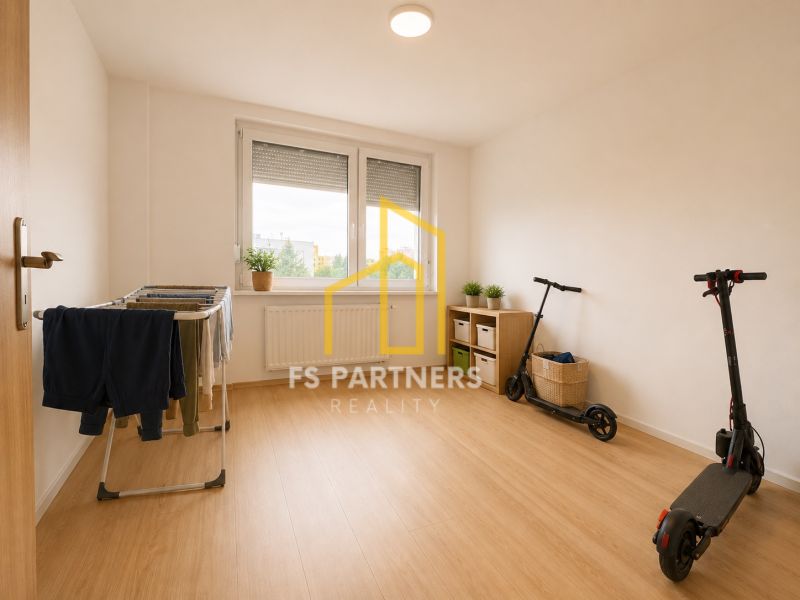 A room in a 3-room apartment with a wooden decor floor, a drying rack, and scooters.