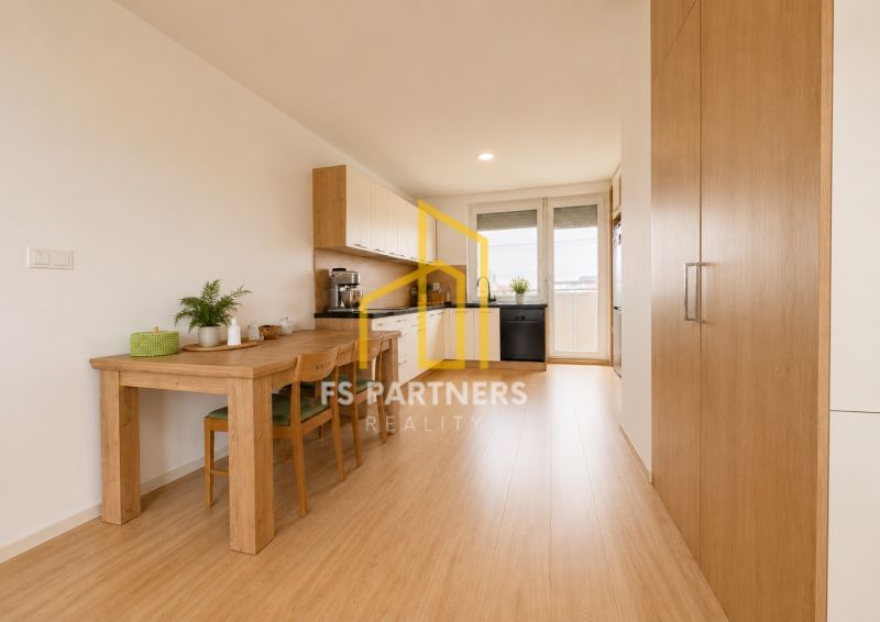 A kitchen in a 3-room apartment with a dining table and a floor with a wooden decor.