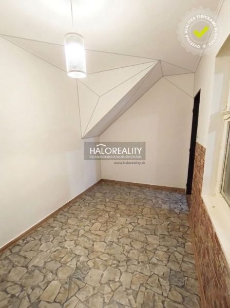Living room in a 3-room apartment with a shelving unit and flooring with a wood decor.