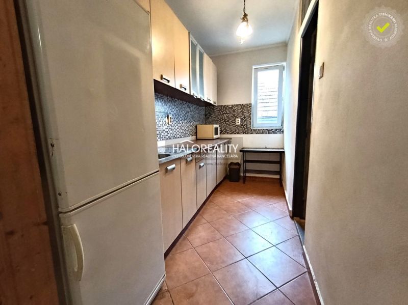 A kitchen in a 3-room apartment with tiles and a light cabinet.