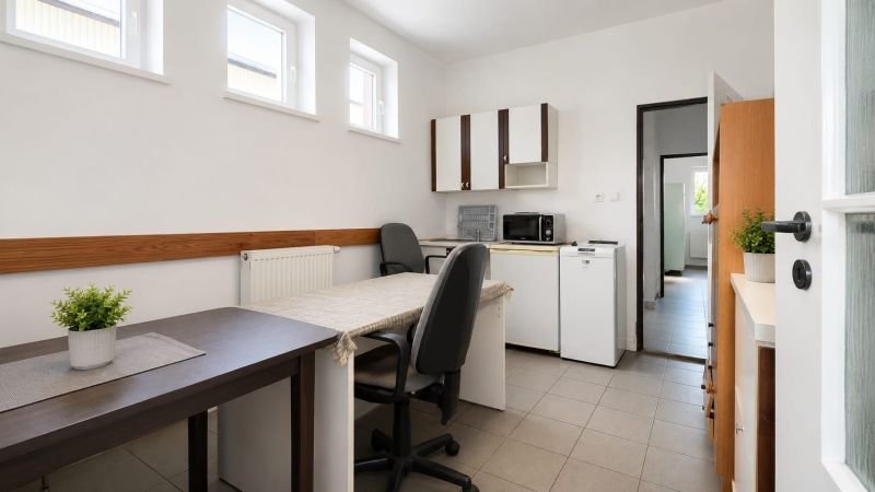 Interior of a warehouse and hall with an office, table, chairs, and kitchen appliances.