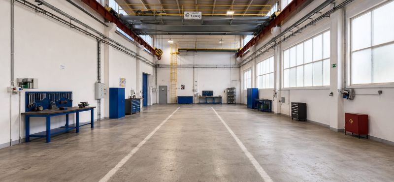 A spacious hall with work desks and tools, a floor with a wooden decor.