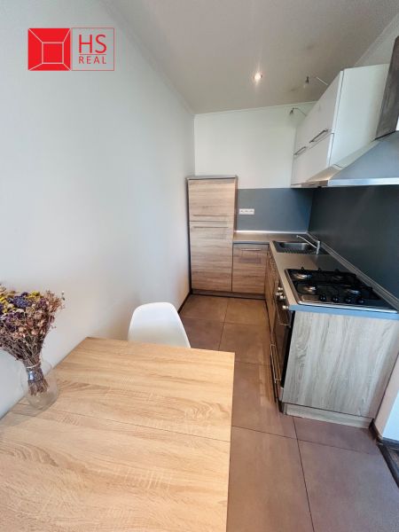 A kitchen in a 3-room apartment with a kitchen unit and a dining table with a wooden decor.