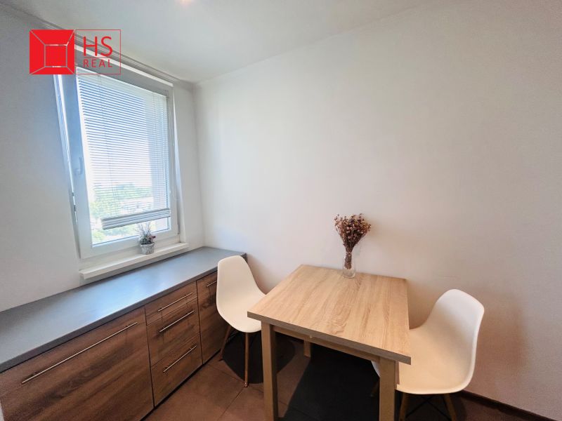 Dining room in a 3-room apartment with a wooden table, chairs, and a sideboard.