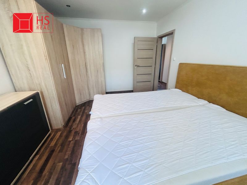 Bedroom with a double bed and a wardrobe in a 3-room apartment with a wooden decor floor.