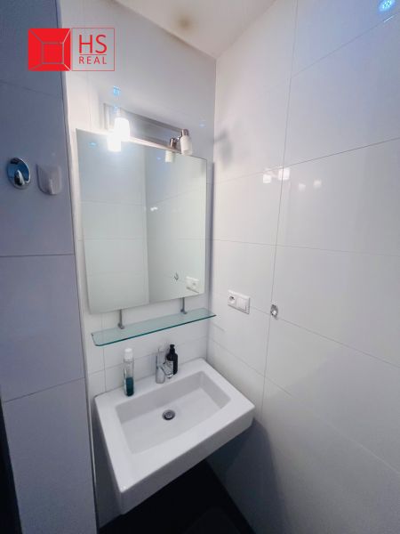 Bathroom sink with mirror in a 3-room apartment, simple and clean design.