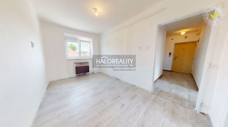 A room with light walls and a floor with a wood decor in a 2-room apartment.