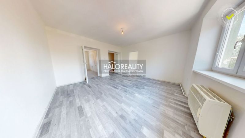 Living room in a two-room apartment with a wooden decor floor and simple lighting.