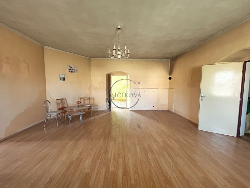 Interior of a family house with a wooden decor floor and simple seating.