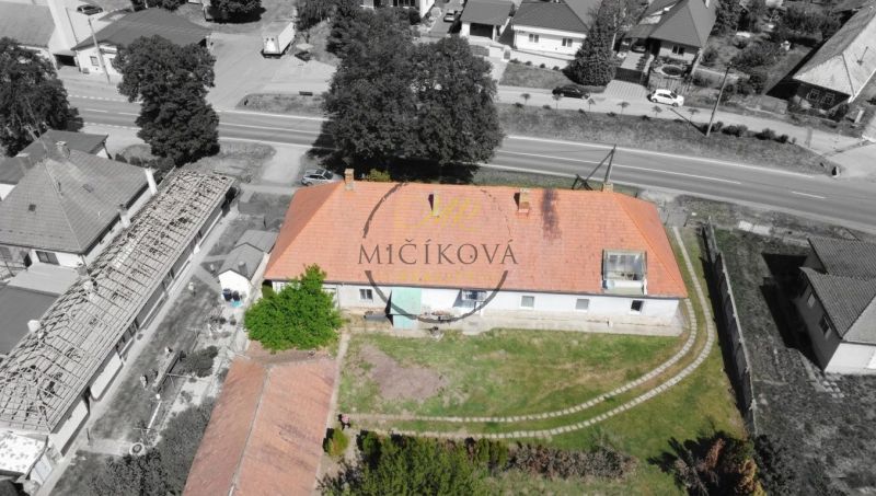 A family house in Čifáre with a reddish roof and a green yard.