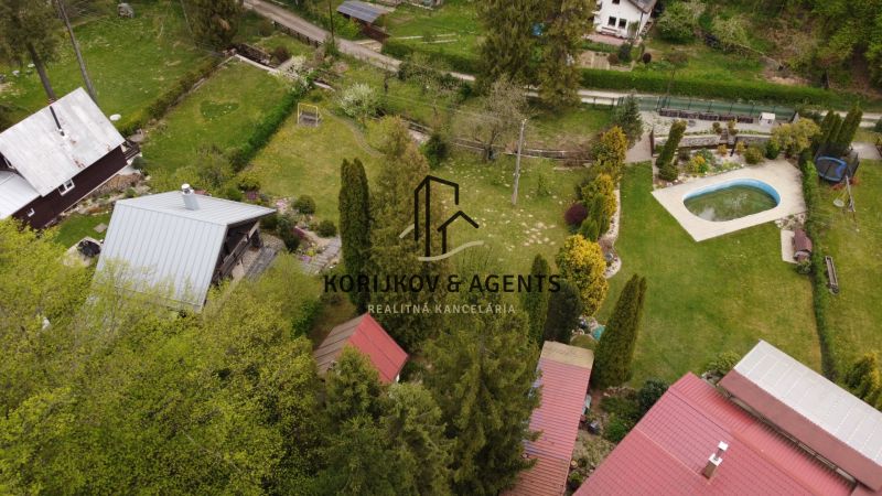 Aerial view of cottages in Nižný Klátov with a pool and gardens.