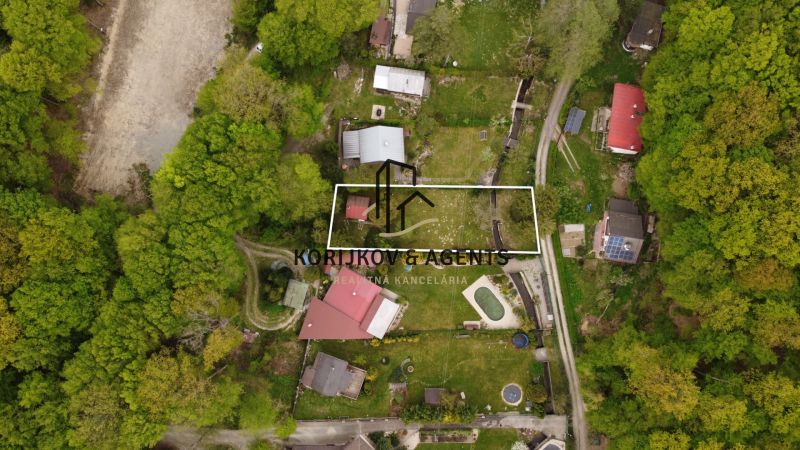 Aerial view of a cottage in Nižný Klátov surrounded by greenery and land.