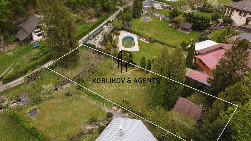 Aerial view of a garden and cottage in Nižný Klátov with trees and a swimming pool.