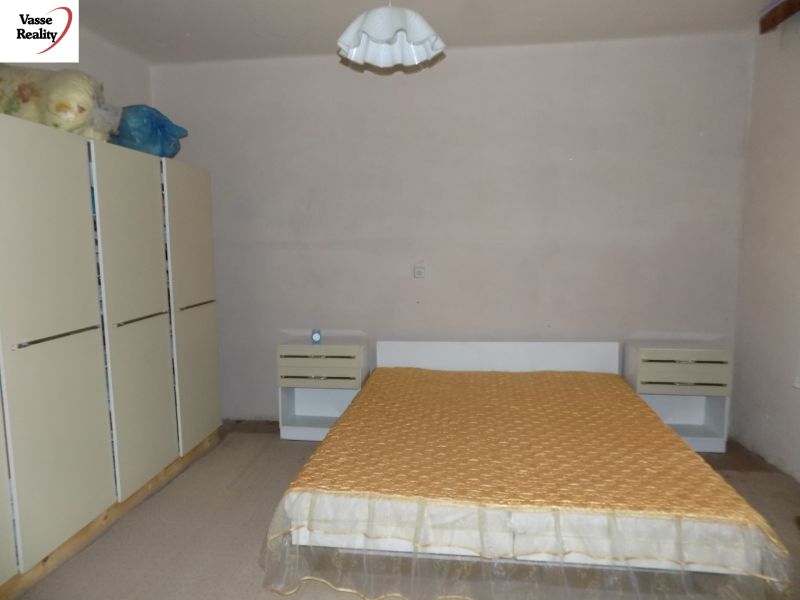 Bedroom in a family house with a double bed, nightstands, and a wardrobe.