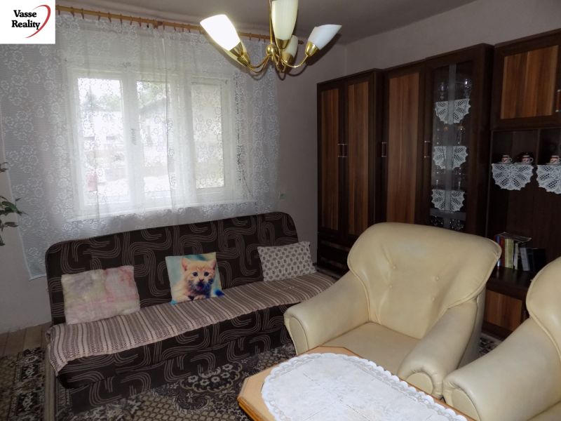 Living room in a family house with a sofa, an armchair, and furniture with a wooden decor.