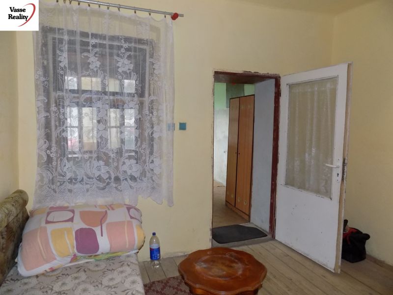 A room in a family house with curtains on the window and a floor with a wooden decor.