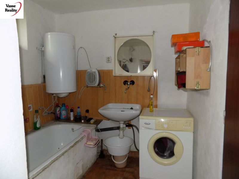 Bathroom in a family house with a bathtub, sink, and washing machine.
