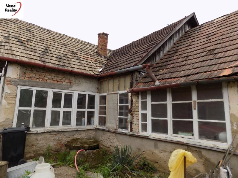 The exterior of a family house in Gbelce with a distinctive old roofing design.