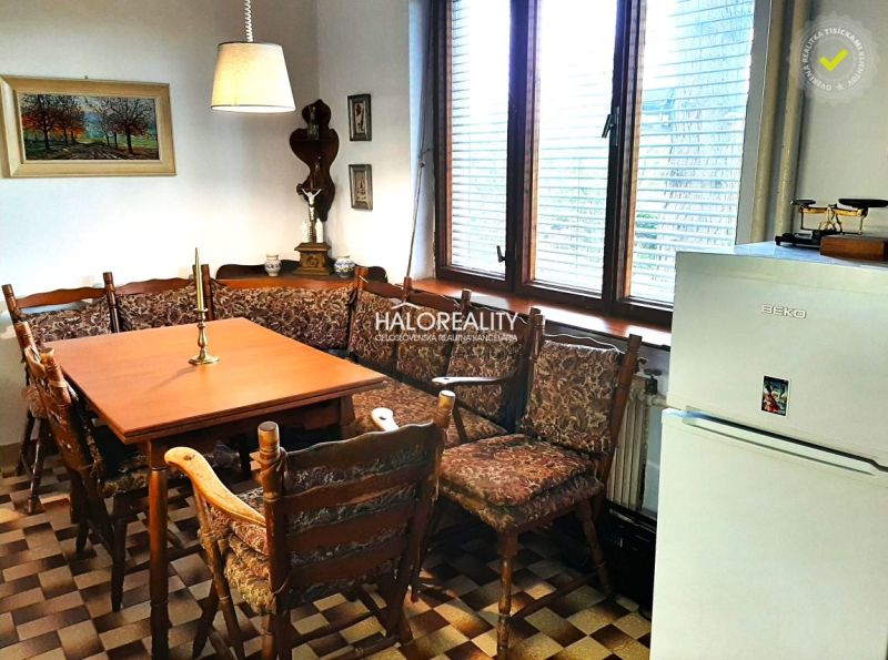 A dining room in a family house with a corner bench and checkered floor, decorations on the walls.