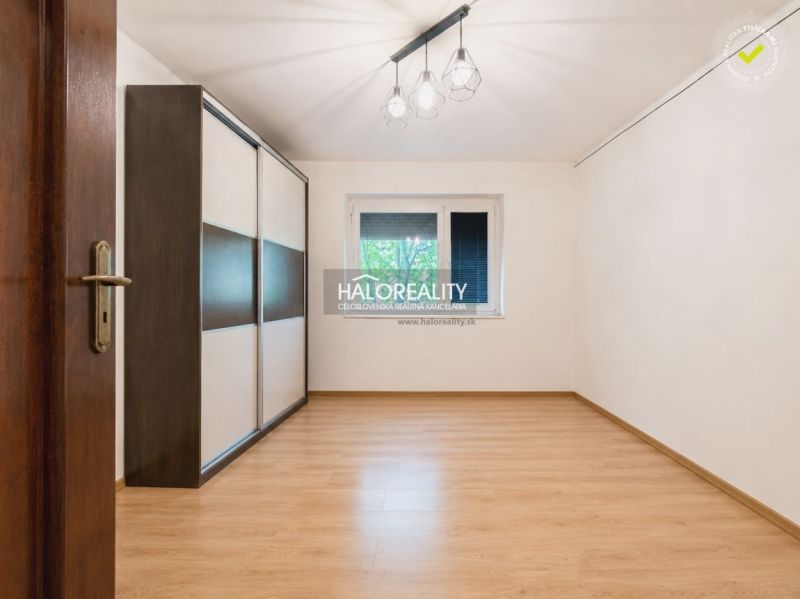 A room in a family house with a wooden decor floor and a built-in wardrobe.