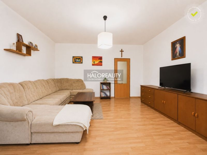 Living room with a corner sofa and a wooden decor floor in a family house.