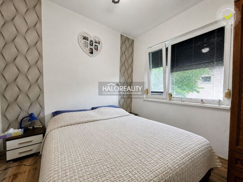Bedroom with a bed and a decorative wall in a family house.