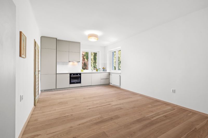 A kitchen with a wood-patterned floor in a 3-room apartment, a bright room with built-in appliances.