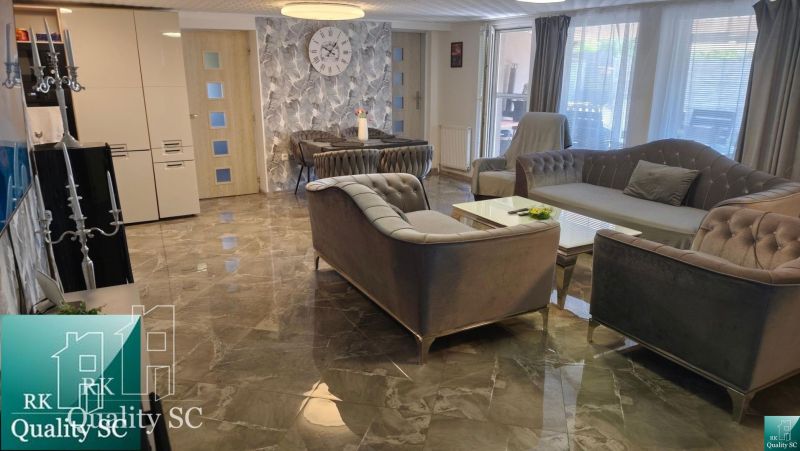 Living room in a family house with a marble floor, comfortable sofa, and decorations.